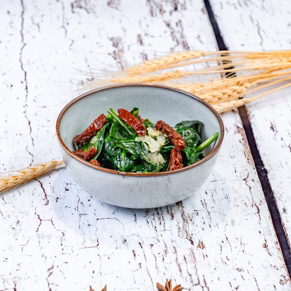 Припущенный шпинат с вялеными томатами